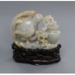 A Chinese pale celadon and russet jade 'quail' carving, wood stand 10cm high including stand