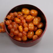 A quantity of loose oval amber beads, gross 55 grams and a hardstone bracelet.