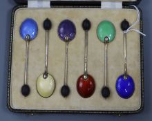 A cased set of six George V silver and polychrome enamel bean end coffee spoons.