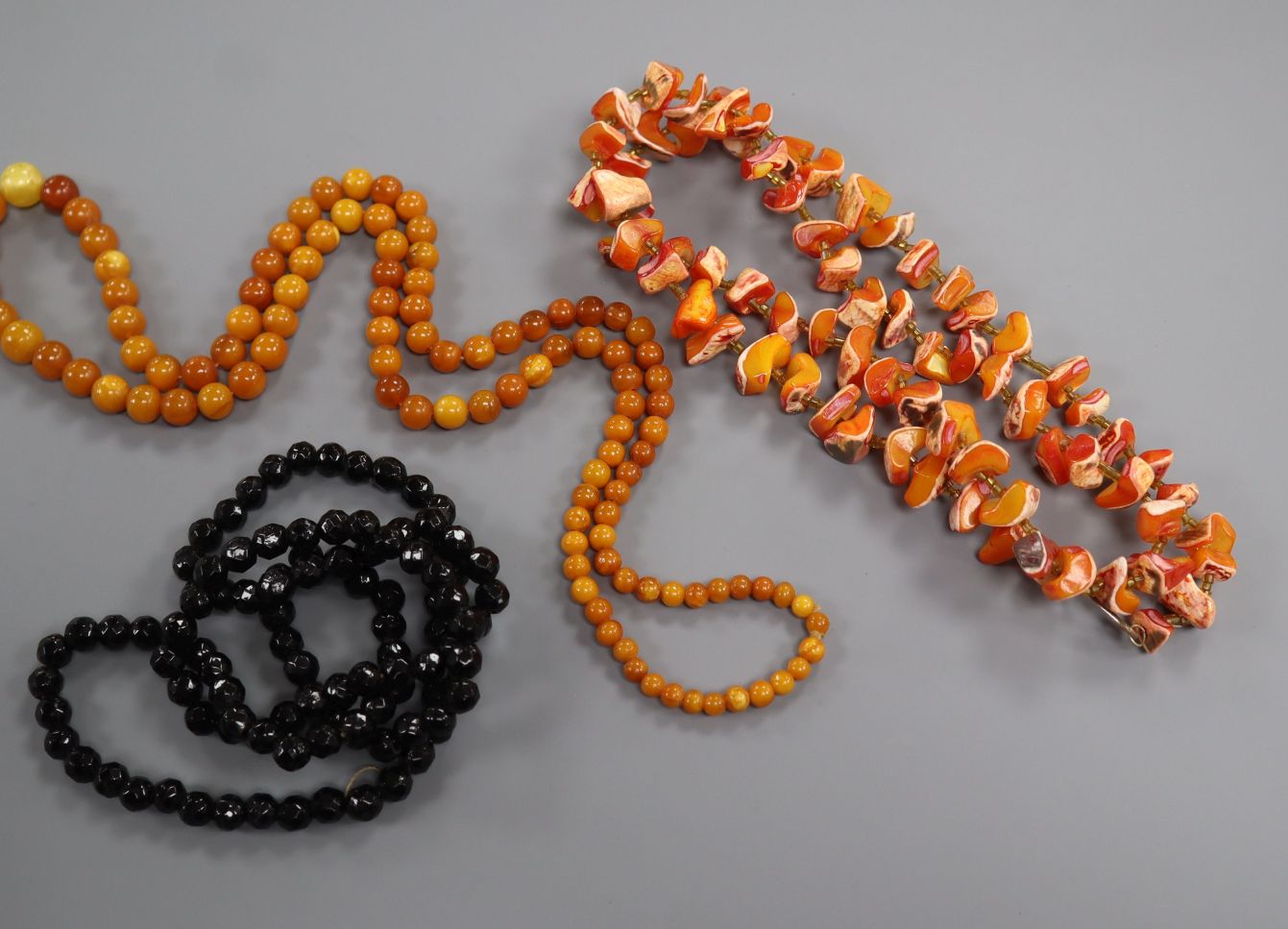 A single strand amber bead necklace, gross weight 28 grams and two other necklaces.