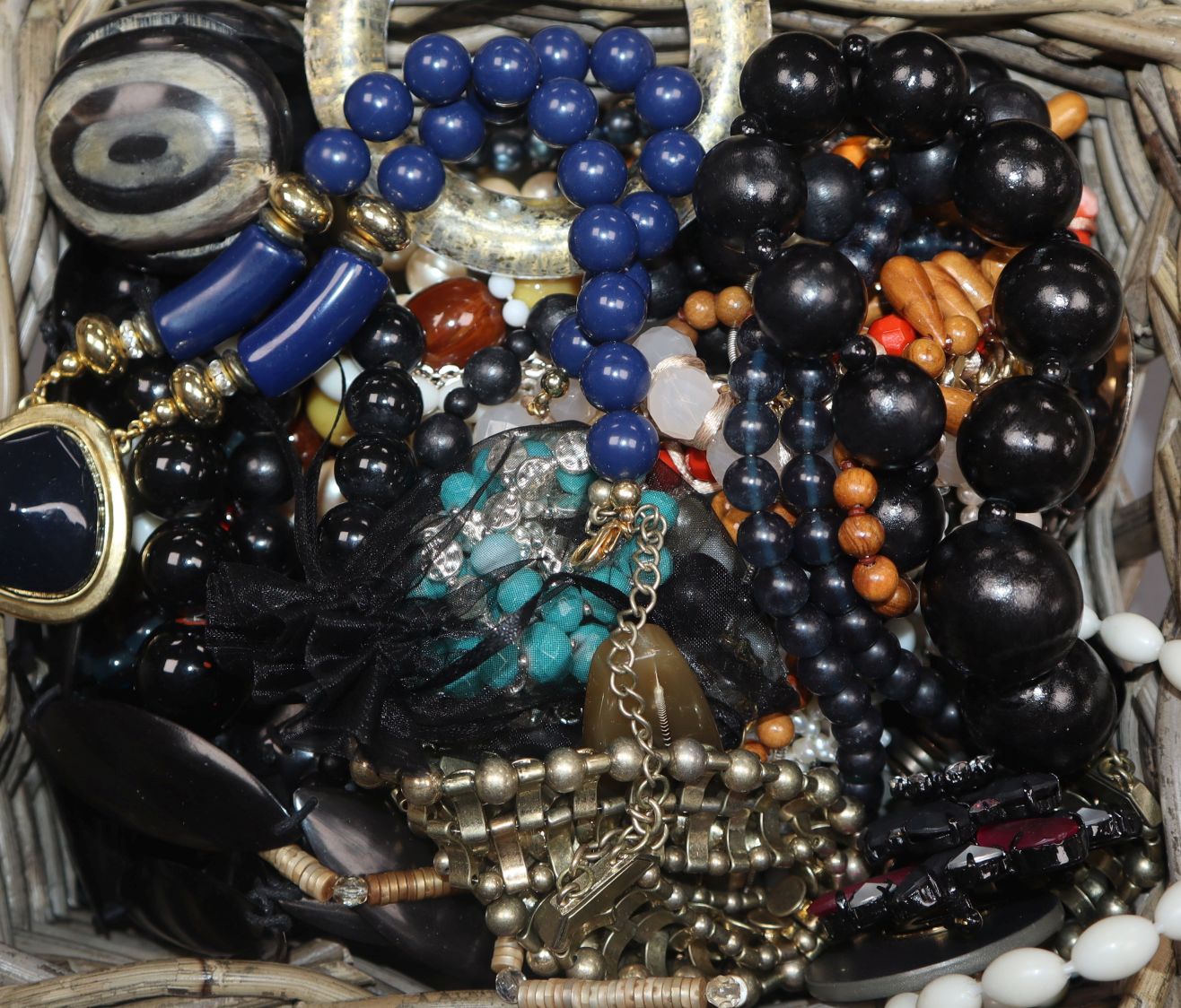 A group of assorted costume jewellery including necklaces and beads and a pair of opera glasses.