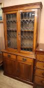 A late Victorian glazed walnut bookcase cupboard W.103cm