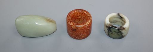 A Chinese Celadon jade pebble snuff bottle and two hardstone archer's rings