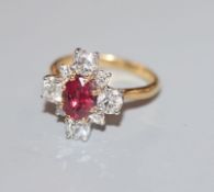 An 18ct yellow metal, single stone ruby and graduated eight stone diamond cluster ring, size M.