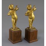 A pair of 17th century Italian gilt metal figures of putto playing mandolins, on later hardwood