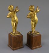 A pair of 17th century Italian gilt metal figures of putto playing mandolins, on later hardwood