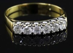A modern 18ct gold and six stone diamond half hoop ring, size W/X.