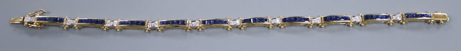 A modern 750 yellow metal, sapphire and diamond set bracelet.