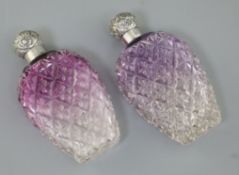 A pair of late Victorian silver lidded amethyst tinted cut glass scent flasks, of baluster form, C.