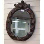 An early 19th century oval carved wall mirror