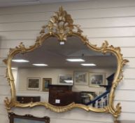 A carved gilt-framed shaped wall mirror W.130cm