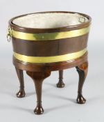 A George III brass bound staved mahogany wine cooler, with zinc liner and lion mask handles, with