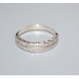 A white metal and twin row diamond set half hoop ring, size O.