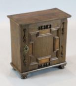 A Charles II oak spice cupboard, the single panelled door enclosing pigeon holes and a base