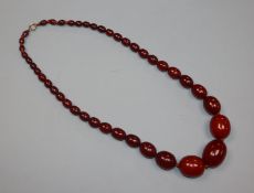 A single strand graduated simulated cherry amber bead necklace, gross weight 75 grams, 62cm.