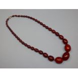 A single strand graduated simulated cherry amber bead necklace, gross weight 75 grams, 62cm.