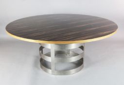 A contemporary macassar ebony veneered circular dining table, with brushed steel strapwork drum