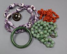 A nephrite bangle, tortoiseshell and pique brooch and three necklaces including coral.