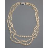 A triple strand graduated cultured pearl necklace, with paste set clasp, 40cm.