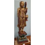 A Tibetan carved giltwood figure of a monk on mirrored plinth base