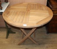 A circular teak folding garden table Diam.90cm