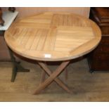 A circular teak folding garden table Diam.90cm