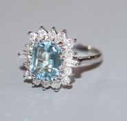 A modern 18ct white metal, aquamarine, baguette and round cut diamond set cluster ring, size K/L.