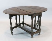 An early 18th century oak oval topped gateleg dining table, with turned and squared underframe,