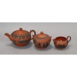 Three Wedgwood Rosso Antico items - a teapot and cover, milk jug and sucrier