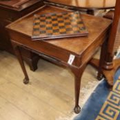 A George II mahogany backgammon table having reversible baize-lined top with counter wells and