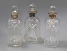 A pair of silver collared dimple moulded glass decanters and another with plated mount
