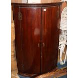 A George III mahogany bow-fronted corner cupboard W.69cm