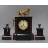 A rouge and black marble clock garniture, the clock of architectural form with enamelled Arabic dial