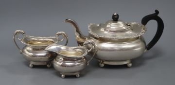 An Edwardian three-piece silver tea service, London shape with shell and gadroon borders on ball