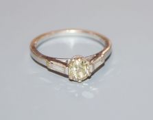 A modern 18ct white gold and fancy yellow single stone diamond ring, with baguette cut diamond set