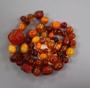 A graduated amber bead necklace, some beads carved with insects or animal heads, gross weight 119