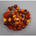 A graduated amber bead necklace, some beads carved with insects or animal heads, gross weight 119