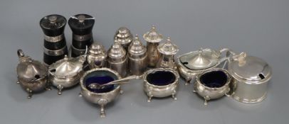 A six-piece silver cruet set, two pairs of urn peppers, a pair of silver-mounted pepper mills, a