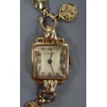 A lady's 9ct gold wristwatch with fancy flower-link bracelet and miniature St Christopher medallion,