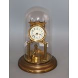 A brass torsion clock under glass dome