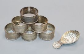 A set of five George V silver serviette rings, one other and a modern silver caddy spoon.