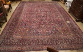 A Tabriz carpet with foliate pattern on a wine field (worn) approx. 480 x 340cm (holed)