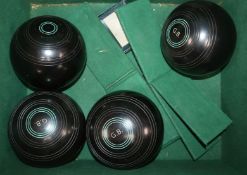 A set of four ebony crown green bowls in original leather case