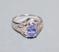 A modern 18k white metal, tanzanite and diamond cluster dress ring, size M/N.