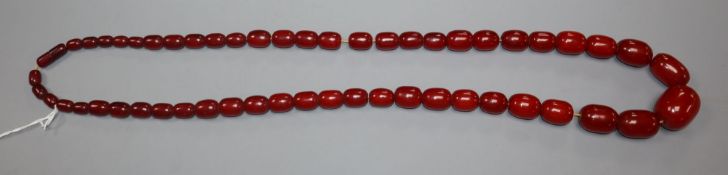 A single strand graduated simulated cherry amber necklace, gross weight 119 grams, approx. 90cm.