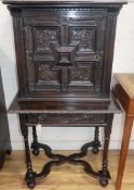 A 17th century design carved oak cabinet on stand W.72cm