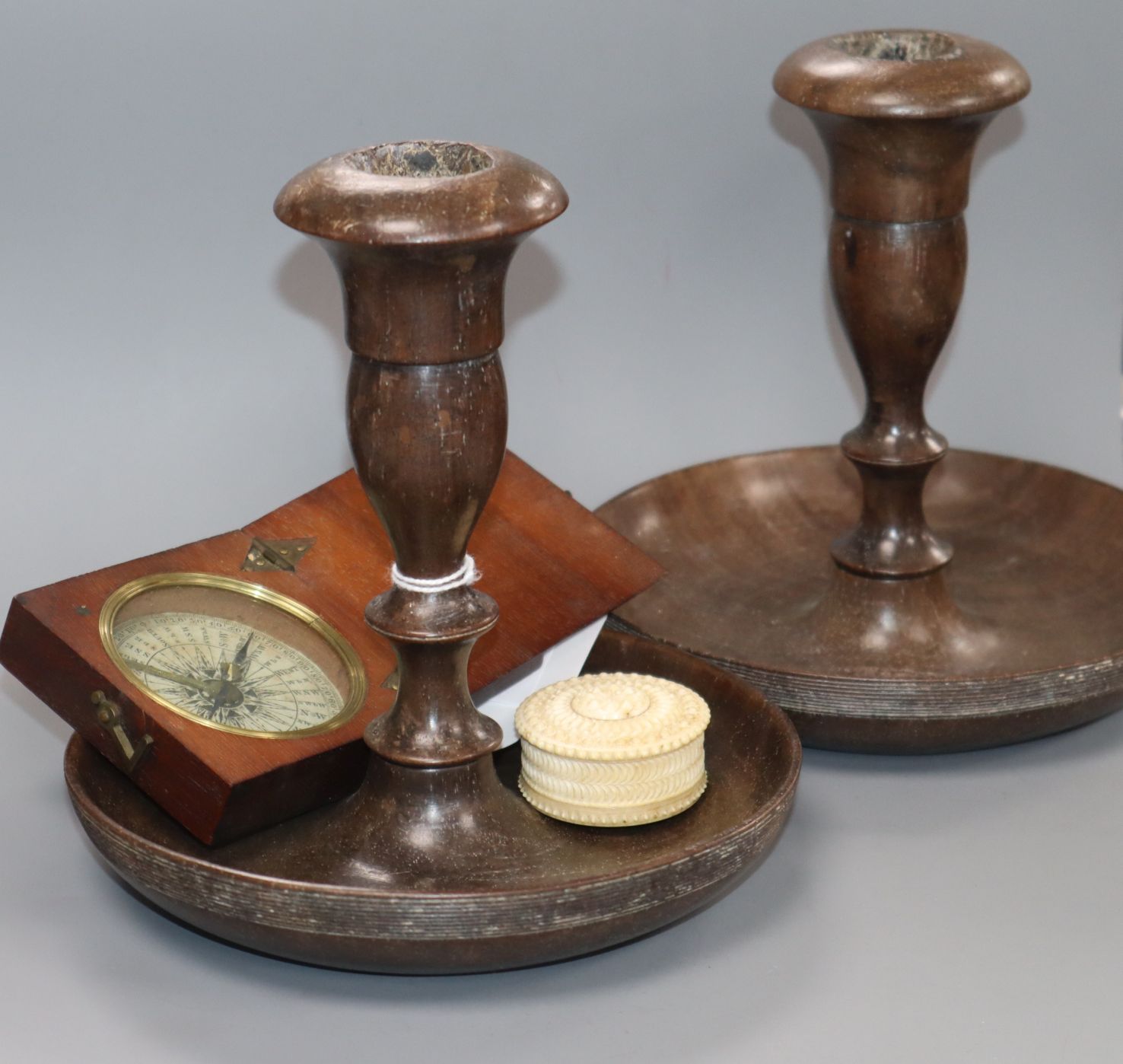 A treen cased compass, a damp detector and a pair of turned wood candlesticks