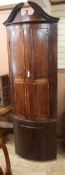 A George III mahogany bow-fronted standing corner cupboard H.230cm