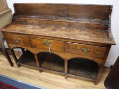 An 18th century oak pot-board low dresser W.135cm