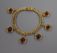 An early 20th century yellow metal and cabochon garnet set drop bracelet, gross 19.7 grams.
